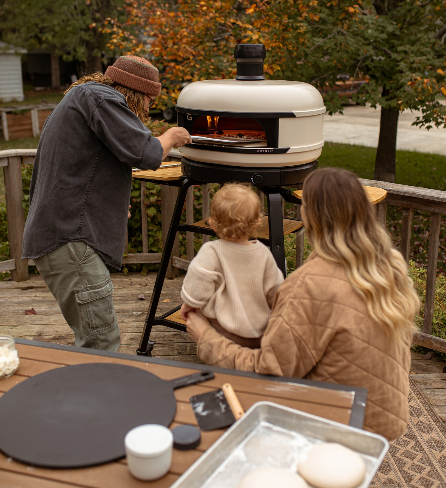 gozney pizza oven in backyard with family cooking pizzas